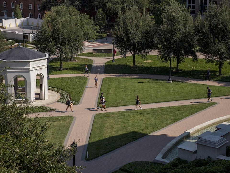 Students walking on the sidewalks next to the gazebo on the SMU Cox campus