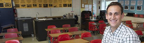 Teacher posing in an elementary/middle school classroom.